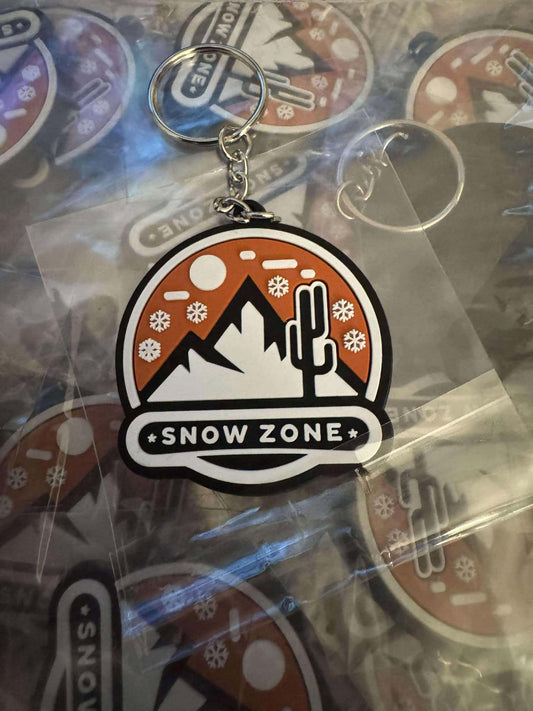 Snow Zone keychain with mountain, cactus, and snowflake design in orange and black colors