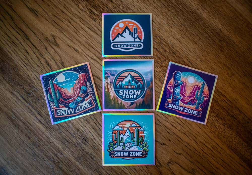 Water and UV proof Snow Zone stickers with colorful mountain and desert designs on wooden surface
